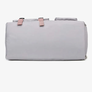 Gray duffel bag with pink buckle straps and top handles.