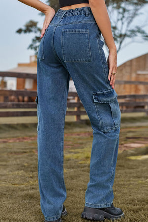 Medium wash denim cargo pants with utility pockets and elastic waistband.