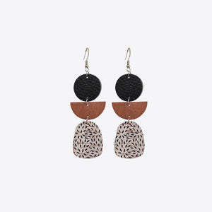 Geometric layered leather and wood earrings with abstract pattern.