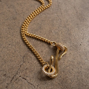 Gold curb chain necklace with a serpentine zirconia clasp and snake detail.