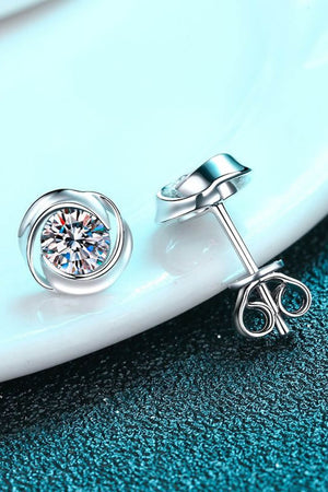 Silver orbital halo crystal stud earrings with a swirling design.