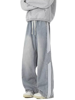 Relaxed fit wide-leg jeans in light blue denim with white side stripes and drawstring waist.