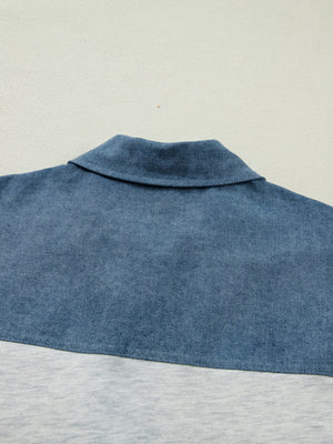 Two-tone denim polo shirt with classic collar and color-block detail.