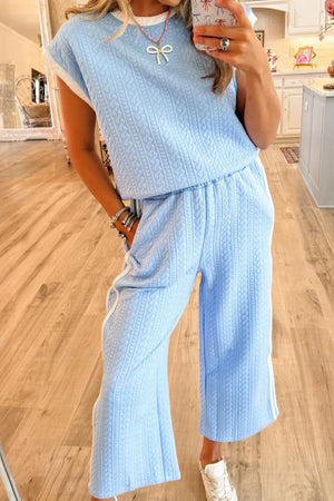 Light blue cable knit loungewear set with contrast trim pants and a sleeveless top.