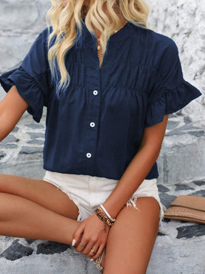 Dark blue button-up blouse with gathered yoke and ruffle sleeves.