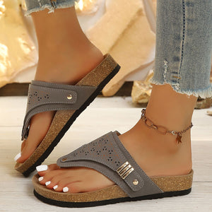 Gray hollow-out toe-post sandals with cork-style sole and adjustable ankle strap.