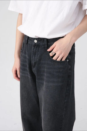 Black denim jeans with a relaxed fit and visible front pockets.