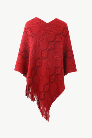Red knit poncho with geometric pattern and fringe detail