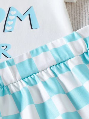 White baby tee with blue Mama graphic and matching blue gingham shorts.