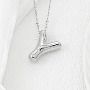 Silver letter pendant necklace with a smooth, rounded abstract shape on a delicate chain.