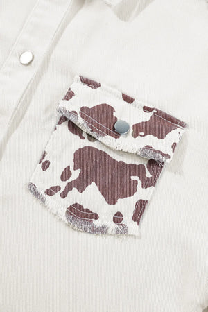 White cow print denim shacket with frayed pocket edges and silver snaps.