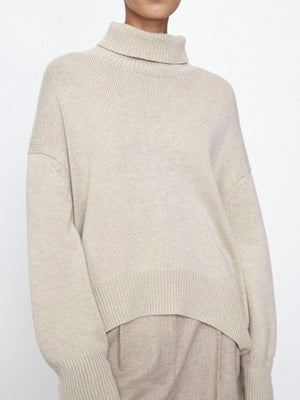Relaxed turtleneck sweater in Ivory with sculptural sleeves and ribbed trim.
