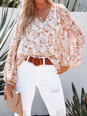 Floral print v-neck long sleeve maternity shirt with balloon sleeves in white with pink and orange blooms.