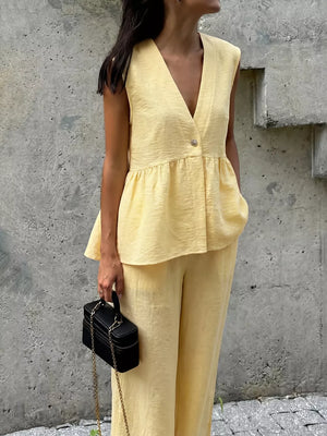 Yellow peplum hem two-piece set with button detail, v-neck sleeveless top and wide-leg pants.