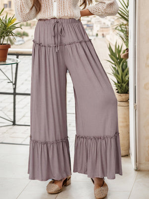 Mauve ruffle edge wide-leg pants with drawstring waist and tiered ruffles.