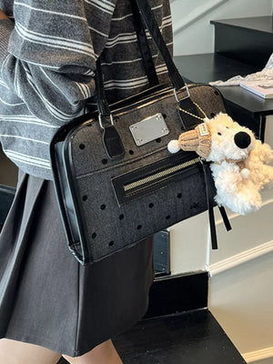 Black polka dot shoulder bag with a fuzzy dog charm and silver plate detail.