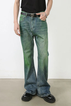 Acid wash flare denim jeans in medium with a green gradient effect, styled with a black belt and platform shoes.