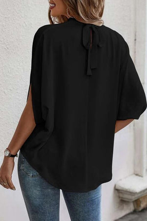 Black blouse with keyhole back and tie detail, featuring drapey split sleeves.