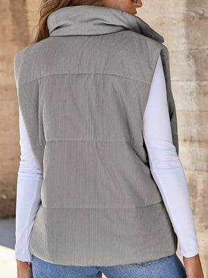Gray ribbed corduroy zip-up vest coat with a high funnel neck, worn over a white long-sleeve shirt.