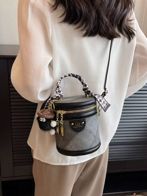 Quilted mini bucket bag in black with scarf detail and fuzzy charm