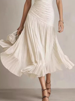 Beige ruched midi dress with a flowing pleated skirt and a-line cut.