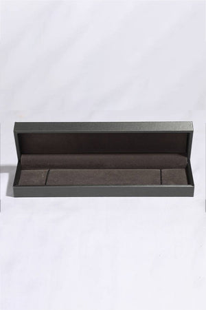 Diamond tennis bracelet jewelry box with dark gray exterior and brown interior.