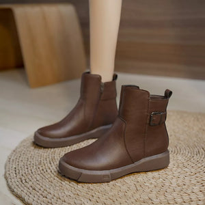 Brown leather ankle boots with round toe, decorative buckle and side zipper.