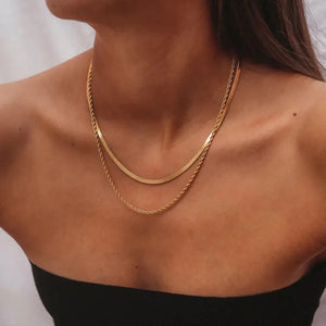 Gold layered serpentine and rope chain necklaces on a model.