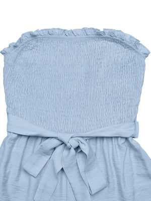 Belted smocked romper in light blue with ruffled neckline and tie waist.