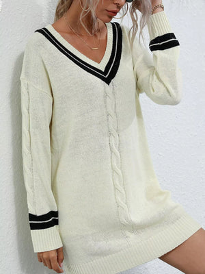 Beige V-neck cable knit sweater dress with black stripe trim on neckline and cuffs.