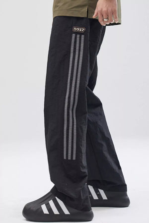 Black sweatpants with side stripes and drawstring detail
