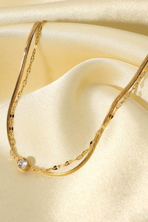 Gold double-strand bracelet with pavé charm and delicate chains.