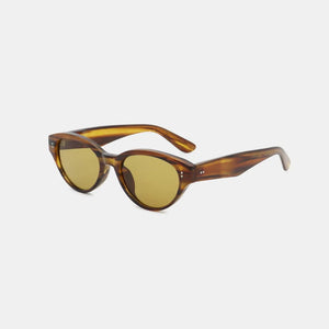 Tortoiseshell oval acetate sunglasses with amber lenses and gold dot accents.