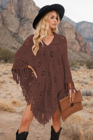 Brown knit poncho with geometric cutouts and fringe, featuring a tie-neck and collar.