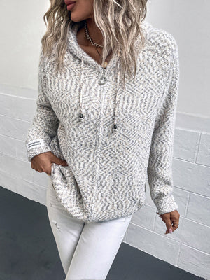 Textured knit zip-up hoodie in a speckled white and grey pattern with a logo detail on the sleeve.