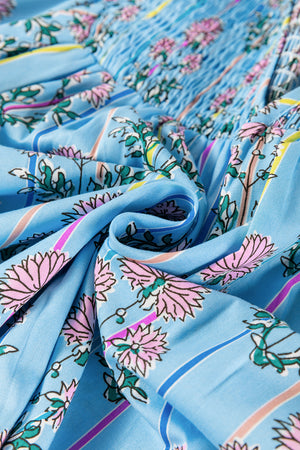 Sky blue floral print smocked yoke blouse with pink flowers and green leaves.