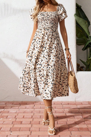 Tiered ruffle sleeve midi dress with abstract print, smocked bodice, and tiered skirt.