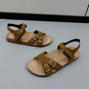 Suede crossover buckle cork sandals in mocha with adjustable straps.