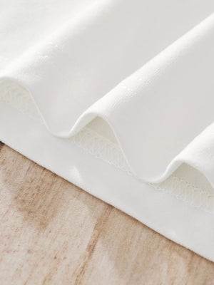 White children's pajama fabric detail showing textured stitching and soft material.