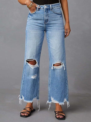 Chic distressed blue denim maternity flare jeans with raw hem and knee rips.