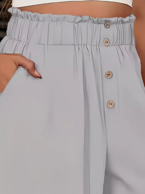 Light gray wide-leg pants with paperbag waist and button detail.