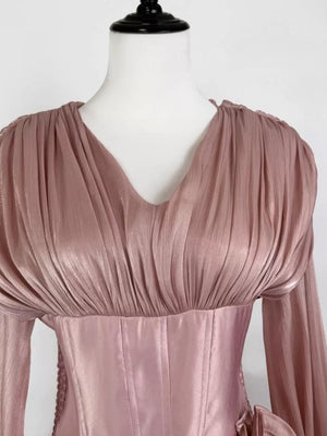 Pink ruffled mini dress with corset waist and long sleeves.