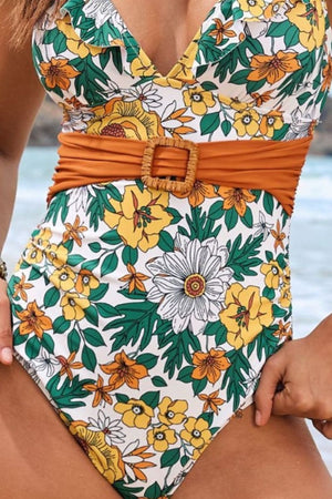 Belted floral plunge swimsuit with a wooden buckle detail and a white, yellow, and green floral print.