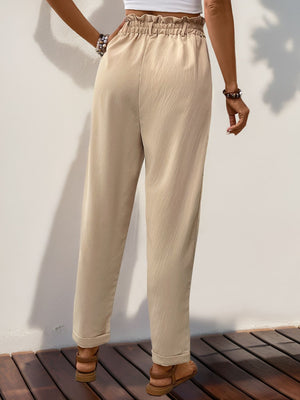 Tan linen blend trousers with gathered waistline and cuffed hems.