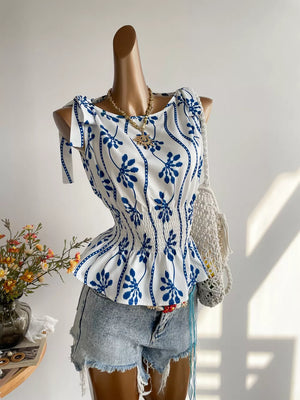 White and blue botanical print smocked blouse with tie shoulder detail and boat neckline.