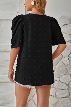 Black textured puff-sleeve blouse with pom-pom details and a casual cut.
