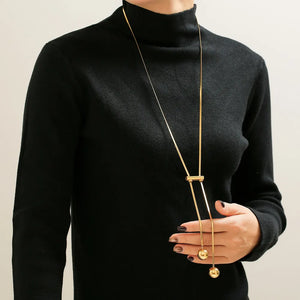 Gold lariat necklace with sphere drops and a bar detail, 18K gold-plated.
