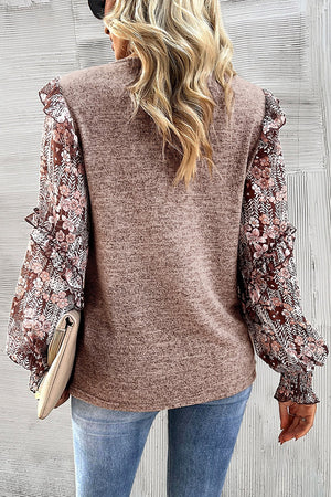 Knit top in dark gray with floral chiffon sleeves and ruffled details.