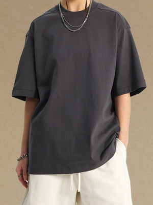 Dark gray boxy cut t-shirt with crew neck and short sleeves, styled with white drawstring shorts.