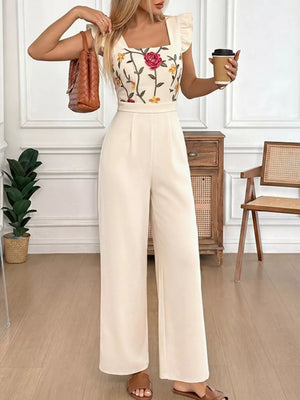 Beige floral embroidered ruffle jumpsuit with square neckline and wide legs.